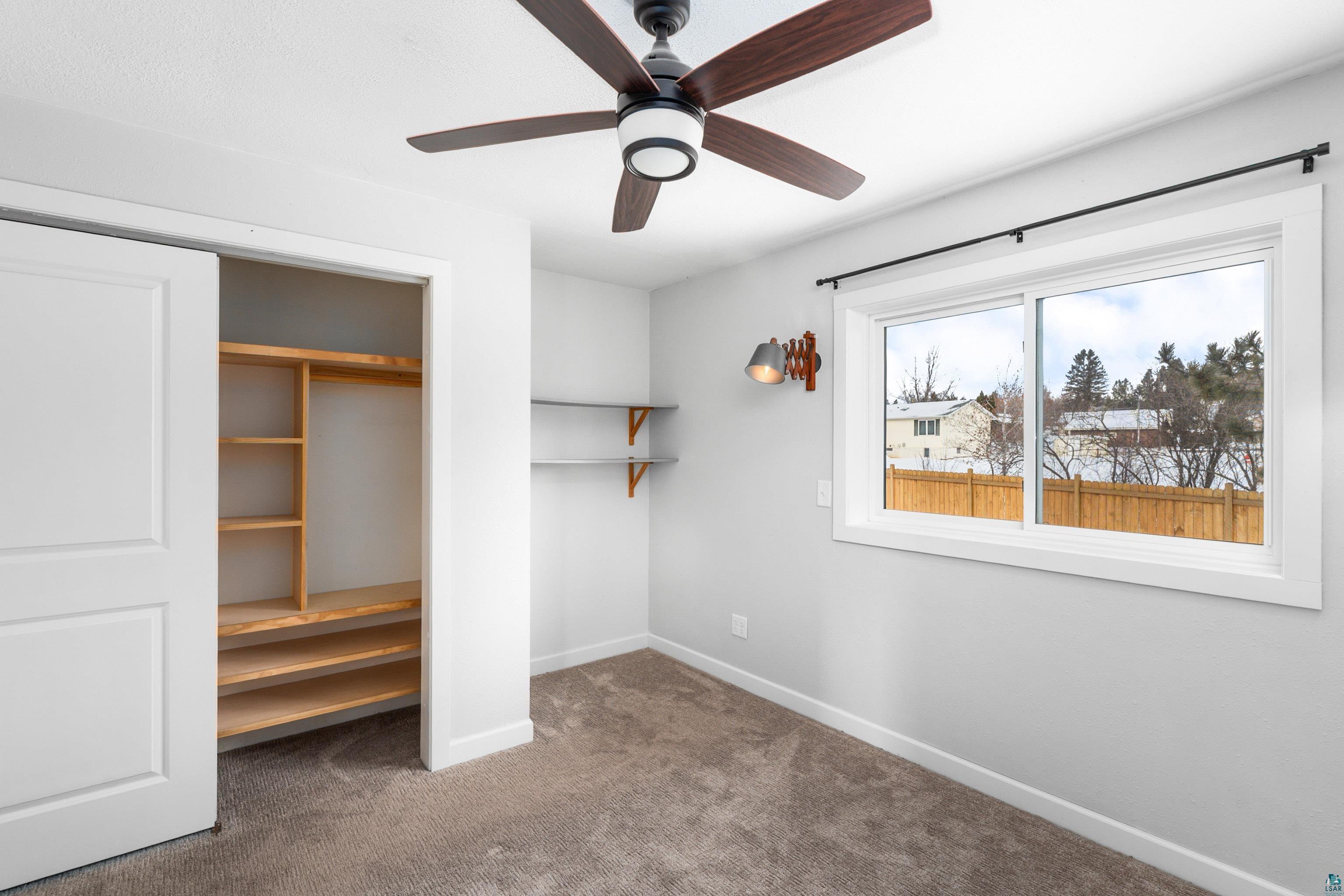 524 14th Avenue Two Harbors, MN 55616 - Photo 12 of 36 Unfurnished bedroom with dark colored carpet, a closet, and ceiling fan