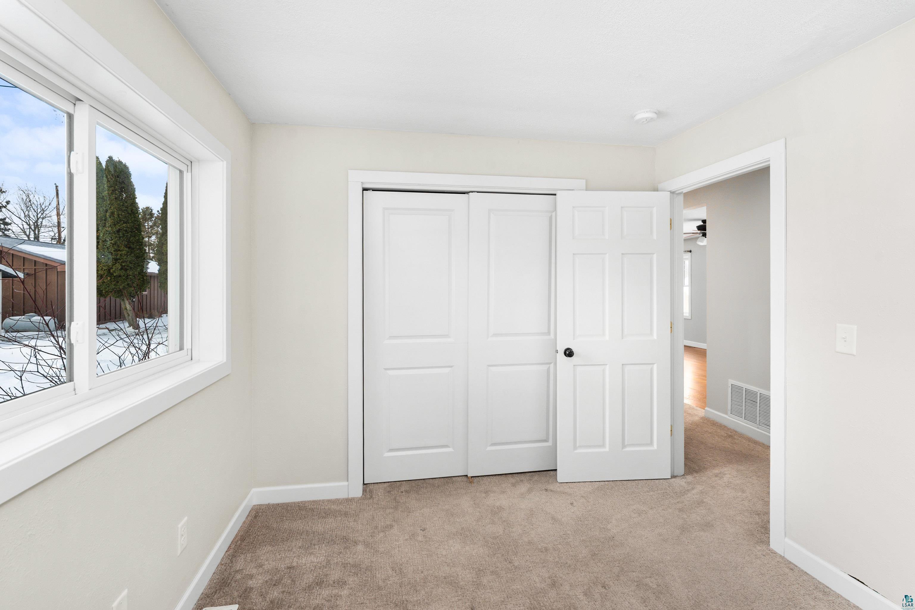 524 14th Avenue Two Harbors, MN 55616 - Photo 15 of 36 Unfurnished bedroom with light carpet and a closet