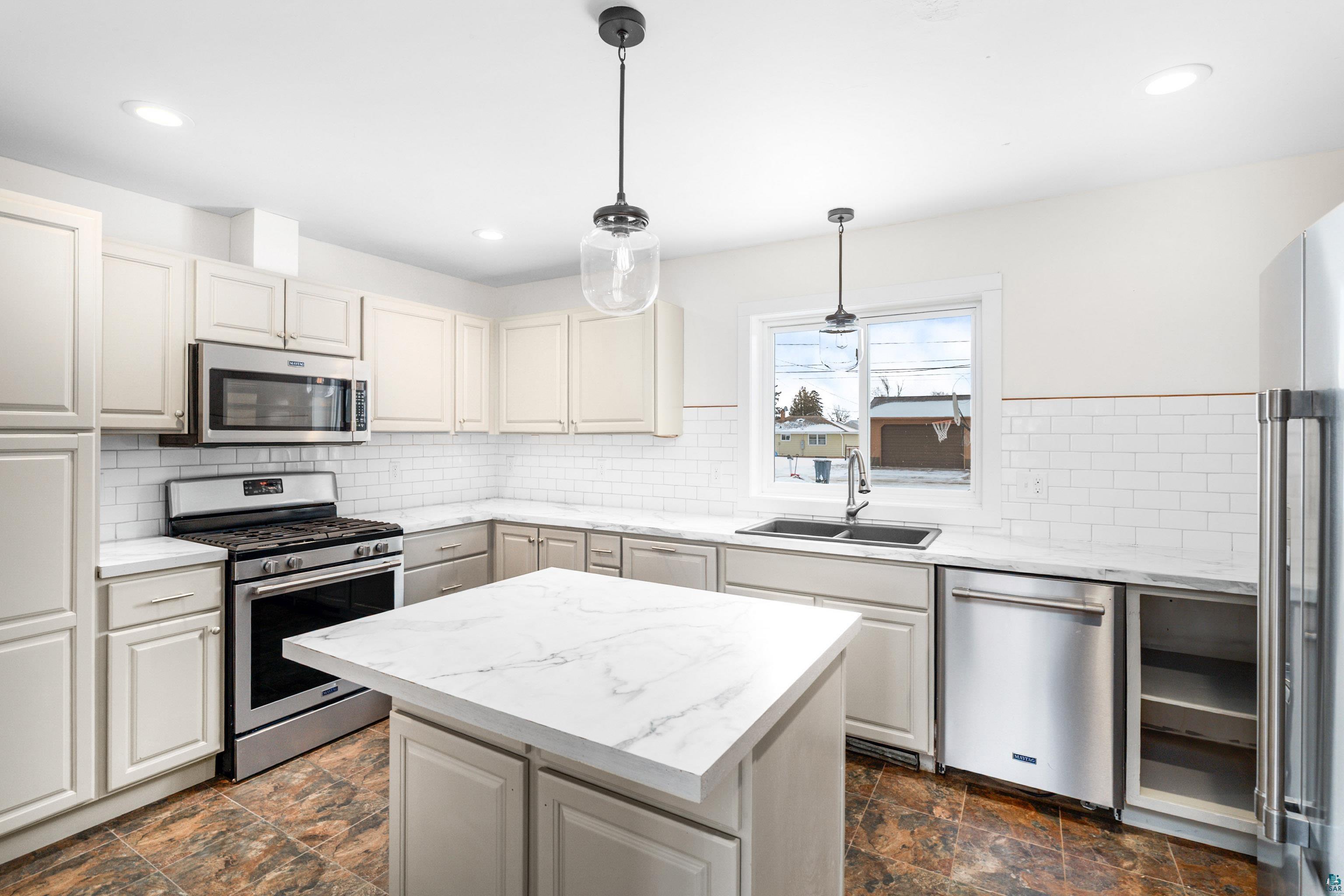 524 14th Avenue Two Harbors, MN 55616 - Photo 5 of 36 Kitchen featuring stone finish floors, stainless steel appliances, pendant lighting, a center island, and recessed lighting