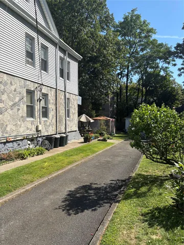 a view of a white house with large windows and a yard