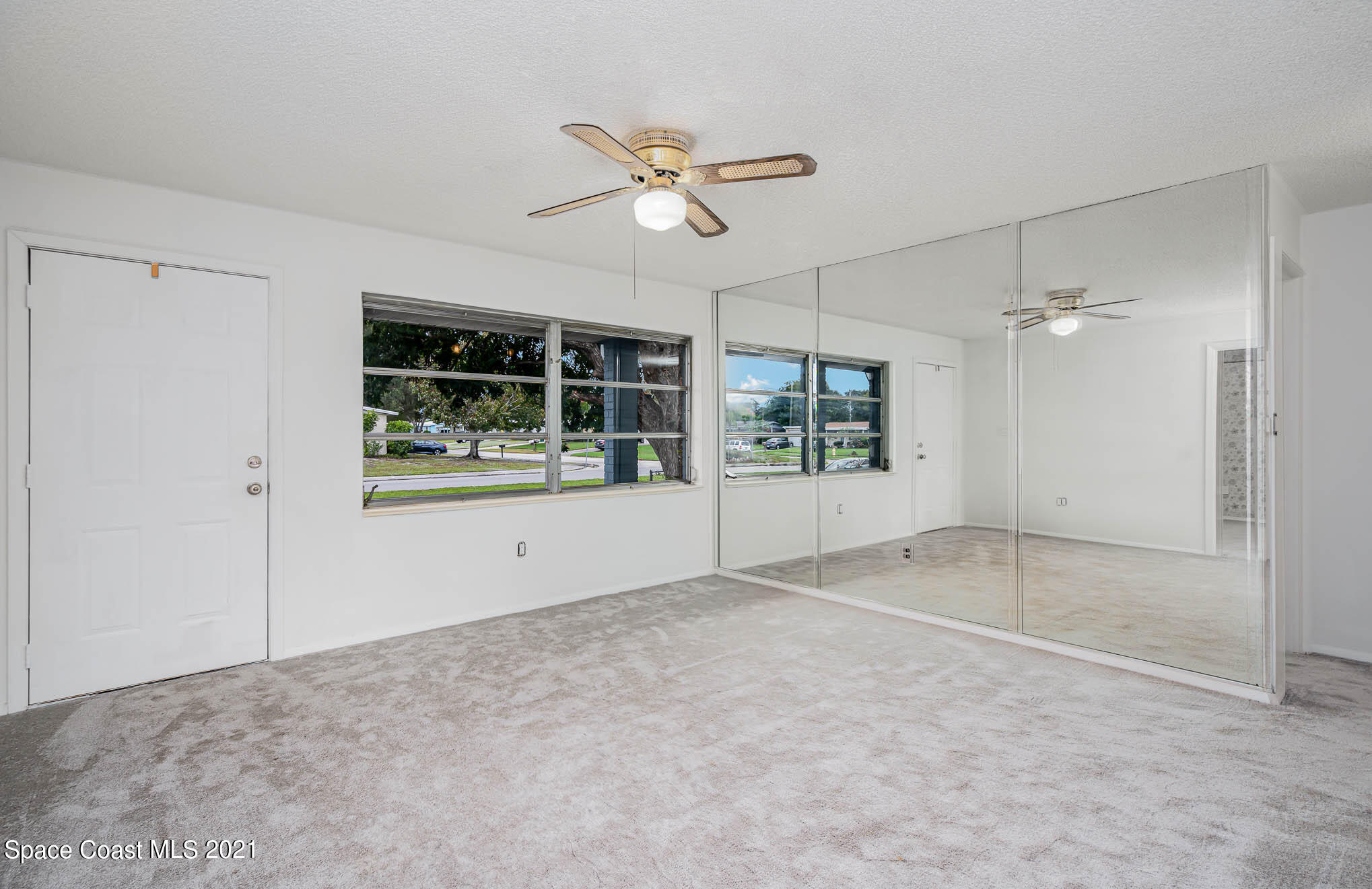 2127 Fatzler Road Melbourne, FL 32935 - Photo 3 of 21 an empty room with windows and ceiling fan