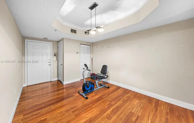 a view of a workspace with wooden floor and a ceiling fan