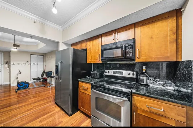 a kitchen with stainless steel appliances granite countertop a stove a sink and a microwave