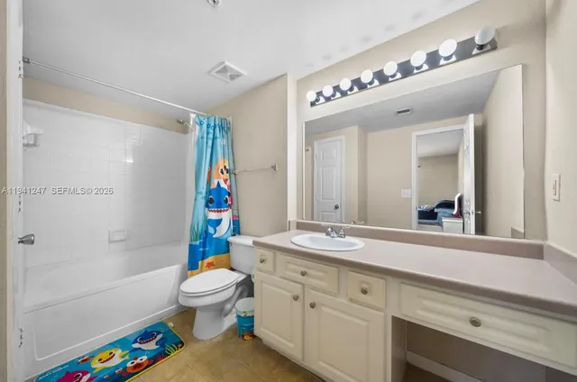 a bathroom with a sink a toilet a shower curtain and a mirror