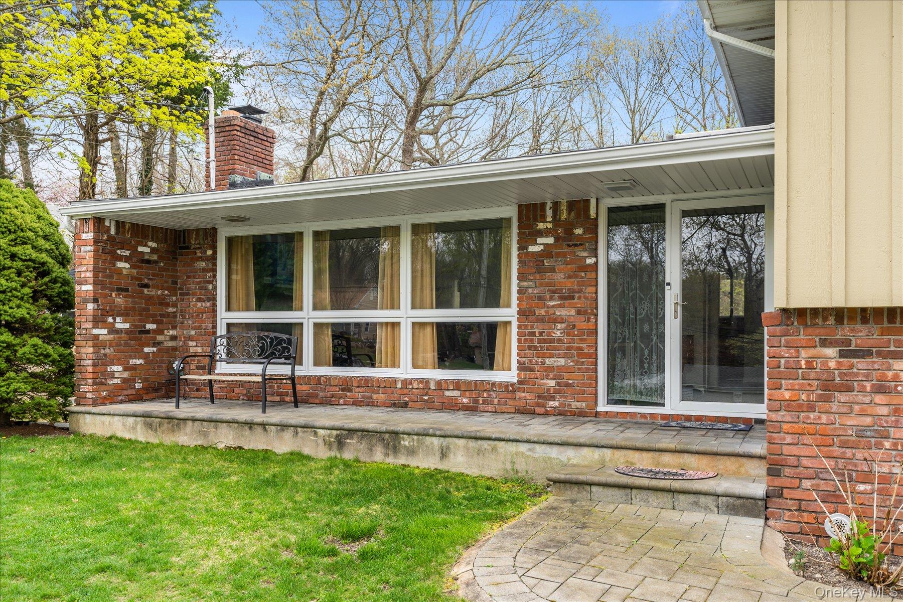 6 George Court Miller Place, NY 11764 - Photo 24 of 33 a view of a house with a large window and a yard with plants
