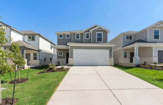 a front view of a house with a yard and potted plants