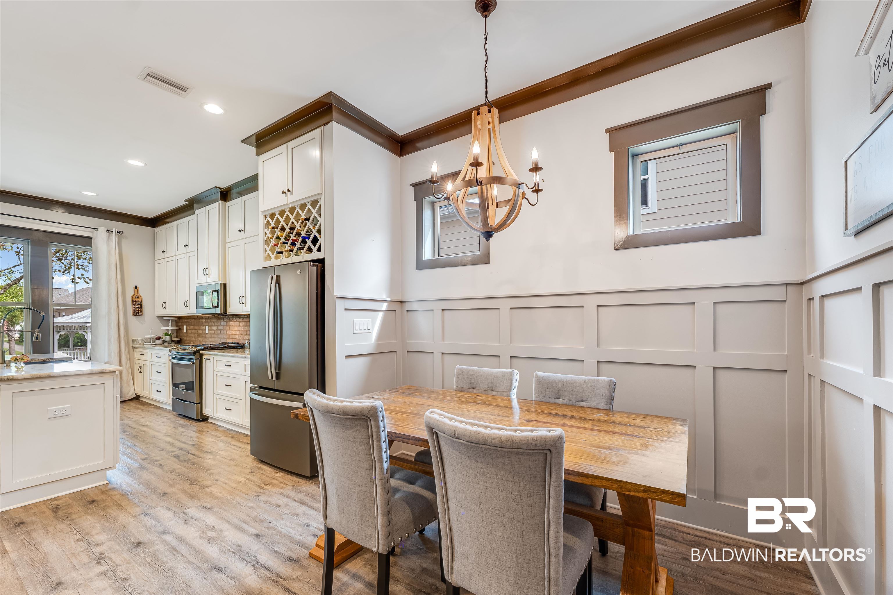 1119 Pink Poppy Lane Foley, AL 36535 - Photo 25 of 38 Dining area with a decorative wall, light wood finished floors, a chandelier, a wainscoted wall, and crown molding