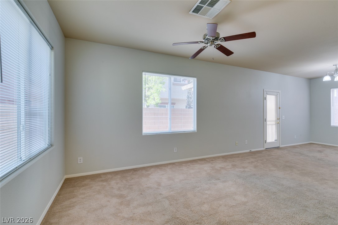 8937 Caledon Ridge Court Las Vegas, NV 89149 - Photo 3 of 43 A spacious room offers comfortable carpeting and natural light through multiple windows, perfect for versatile living.