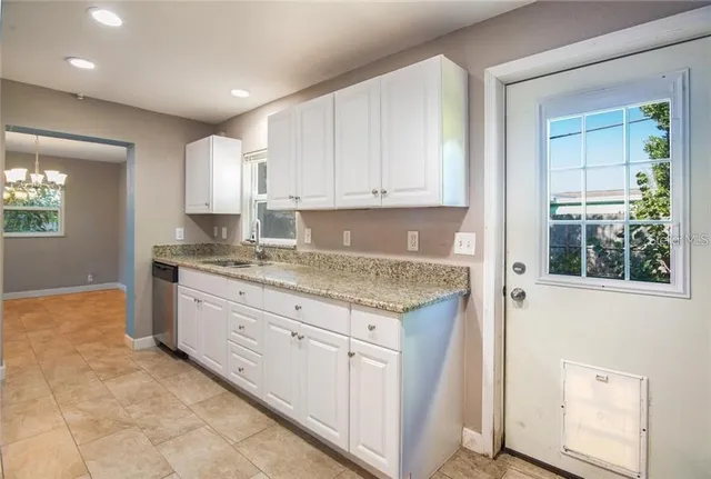 a kitchen with granite countertop white cabinets and white appliances