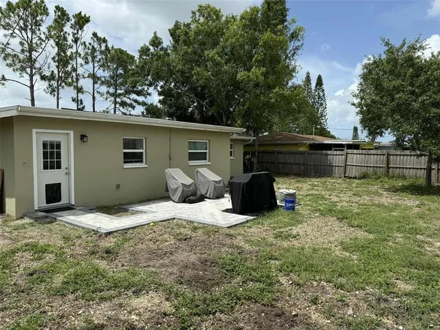 a backyard of a house with table and chairs