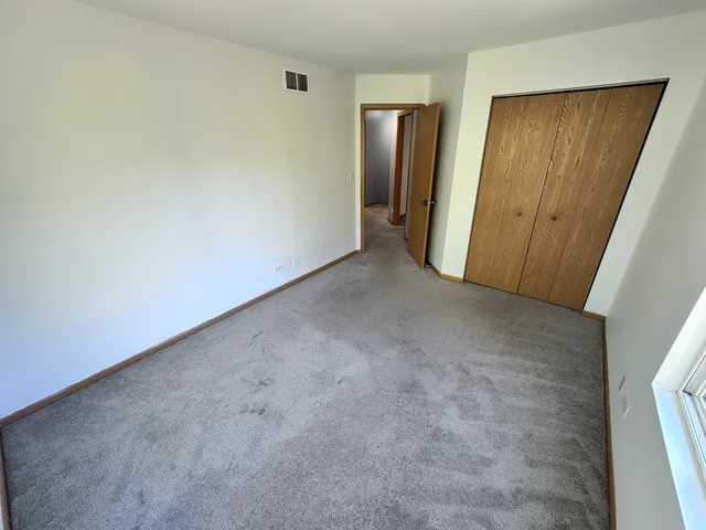 an empty room with closet and mirror