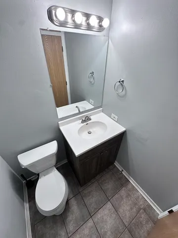 a bathroom with a toilet a sink and mirror