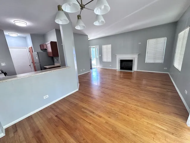 a view of a livingroom with wooden floor and a ceiling fan