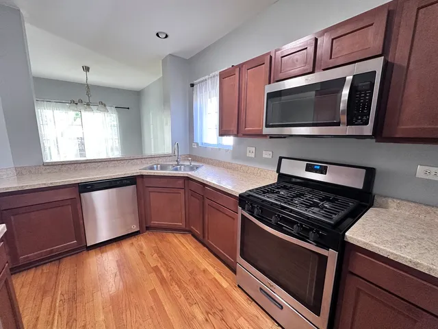 a kitchen with stainless steel appliances granite countertop a stove a microwave and a sink