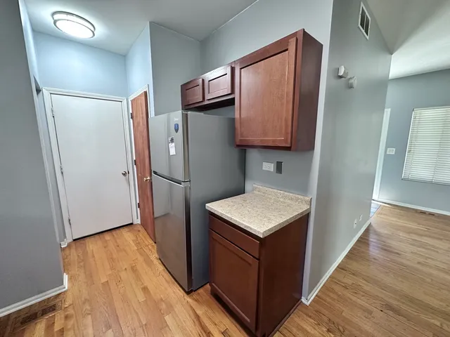 a kitchen with a refrigerator a sink and wooden floor