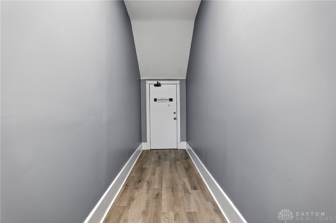7045-7049 Montgomery Road Cincinnati, OH 45236 - Photo 42 of 68 This interior hallway features wood flooring and leads to a functional laundry area.