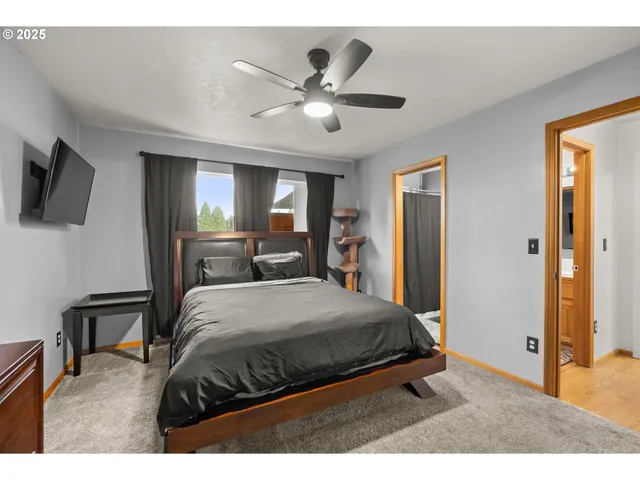 a bedroom with a bed and a ceiling fan
