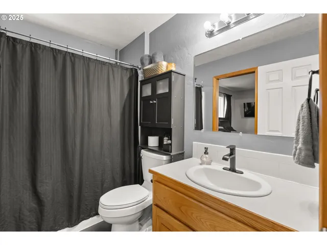 a bathroom with a sink a toilet and a mirror