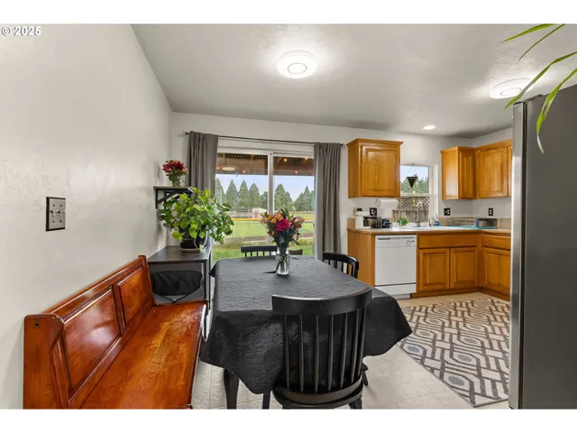 a kitchen with a table chairs refrigerator and cabinets