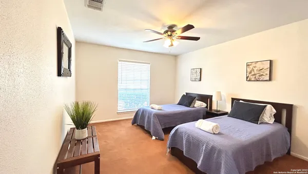 a bedroom with two beds and potted plant