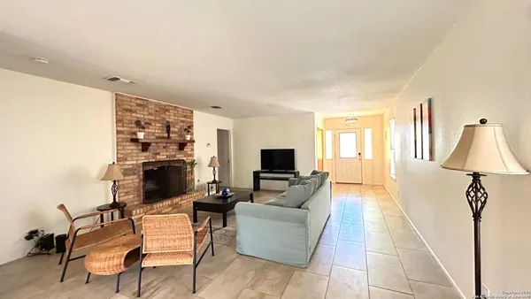 a living room with furniture a flat screen tv and a fireplace