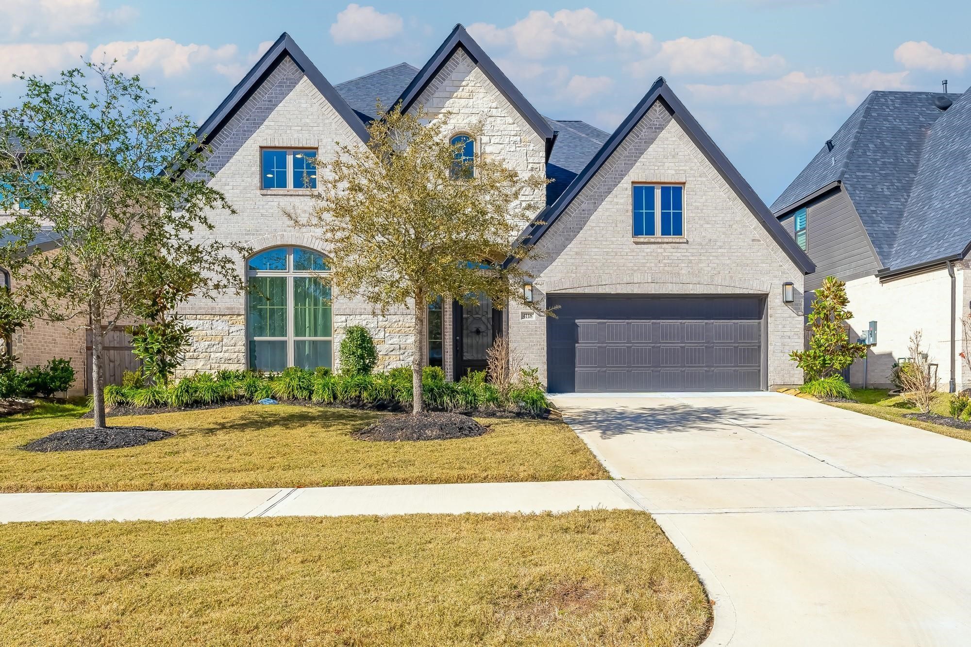 a front view of a house with a yard and garage