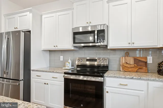 a kitchen with stainless steel appliances granite countertop a sink stove and microwave