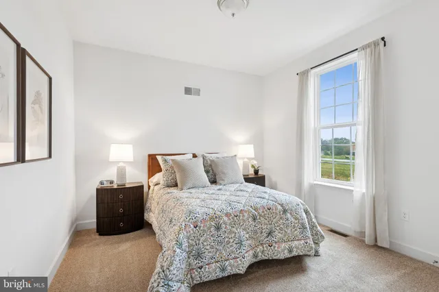 a bedroom with a bed and painting on the wall