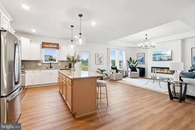 a kitchen with stainless steel appliances granite countertop wooden floors and white cabinets