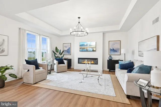 a living room with furniture dining table a window and a potted plant
