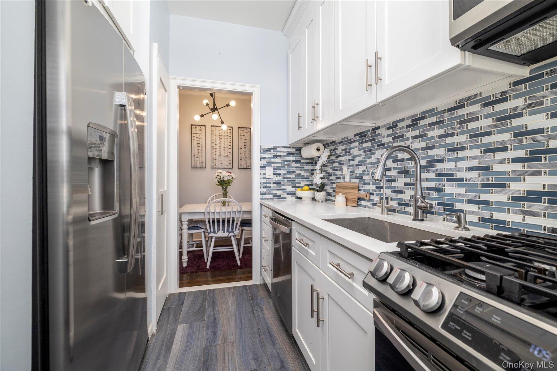 8 Barstow Road, Unit 4J Great Neck, NY 11021 - Photo 3 of 17 a kitchen with a stove and a refrigerator