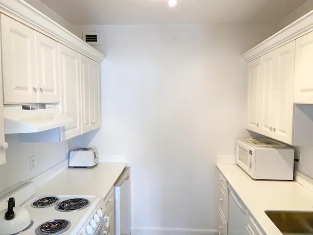 a kitchen with a sink a stove and cabinets