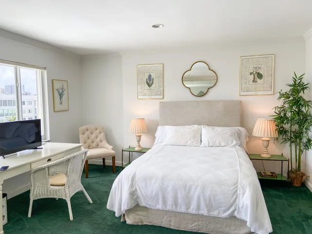 a bedroom with bed and a potted plant