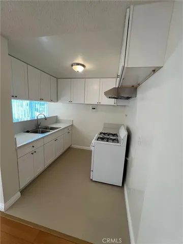 a kitchen with kitchen island a sink a stove and a refrigerator