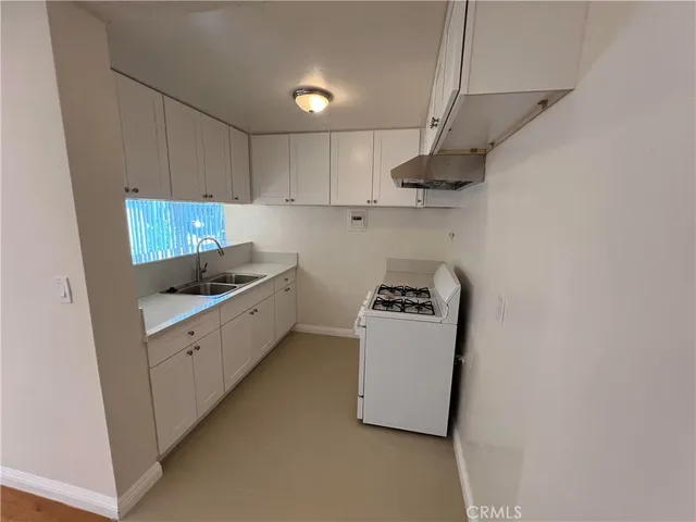 a kitchen with stainless steel appliances granite countertop a sink a stove a refrigerator and cabinets