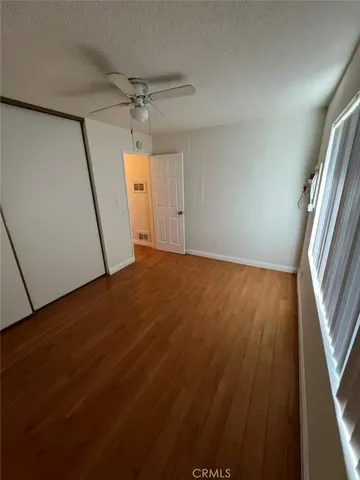 en empty room with wooden floor and windows