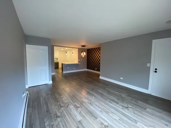 a view of empty room with wooden floor