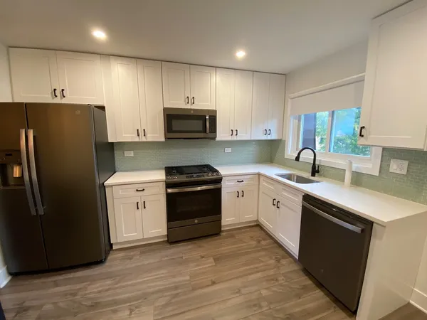 a kitchen with stainless steel appliances a refrigerator stove microwave sink and cabinets