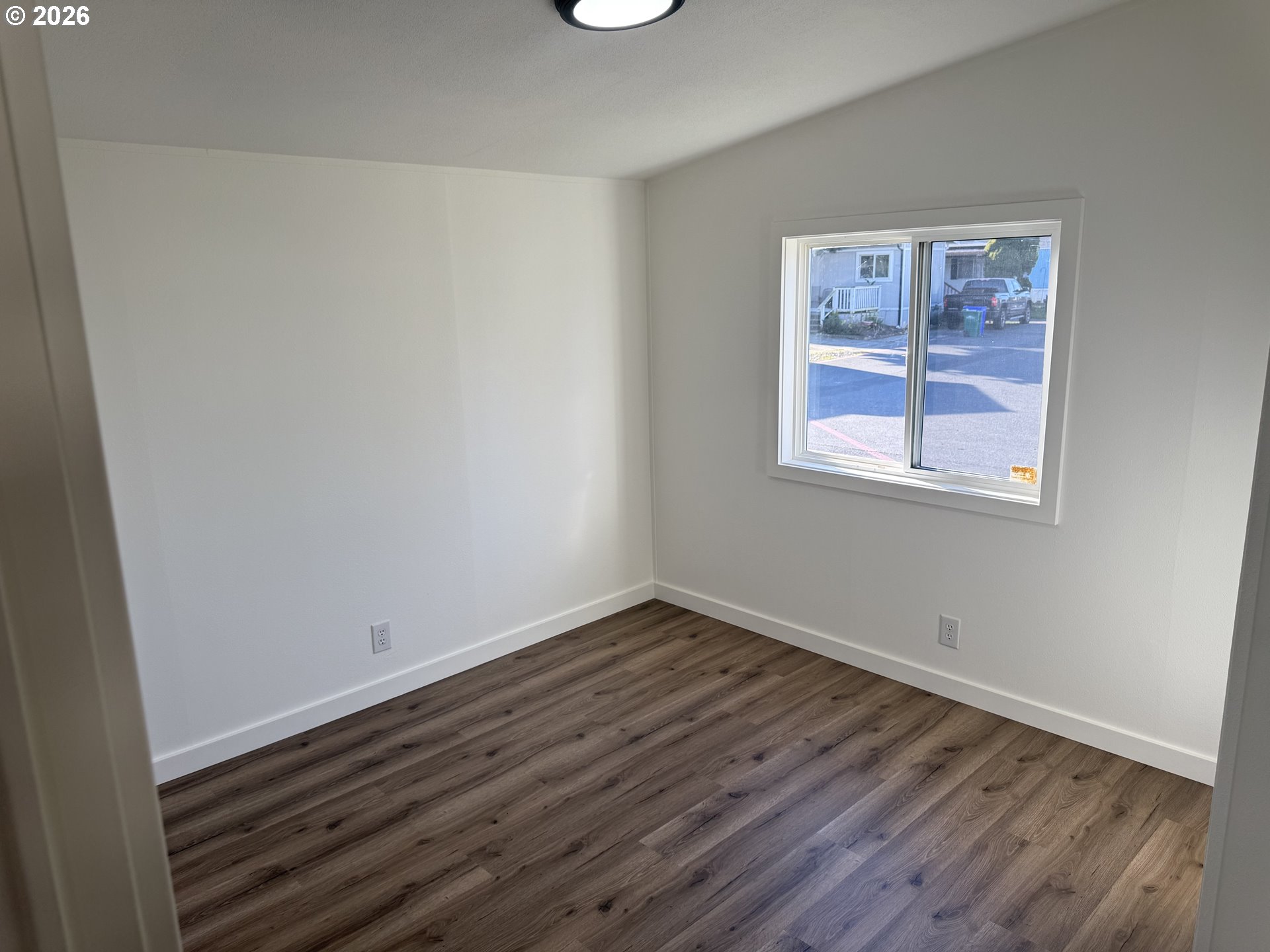 20140 Northeast Sandy Boulevard, Unit 103 Fairview, OR 97024 - Photo 14 of 15 a view of an empty room with wooden floor and a window