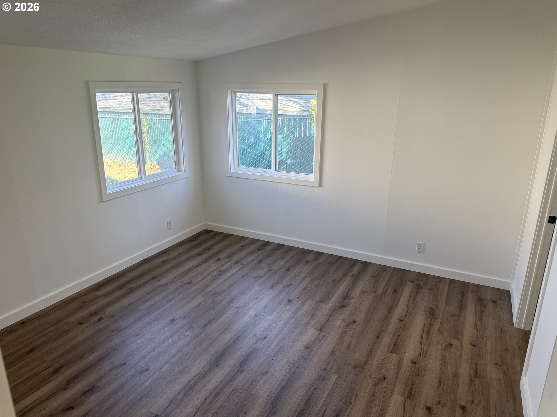 20140 Northeast Sandy Boulevard, Unit 103 Fairview, OR 97024 - Photo 7 of 15 a view of an empty room with wooden floor and a window