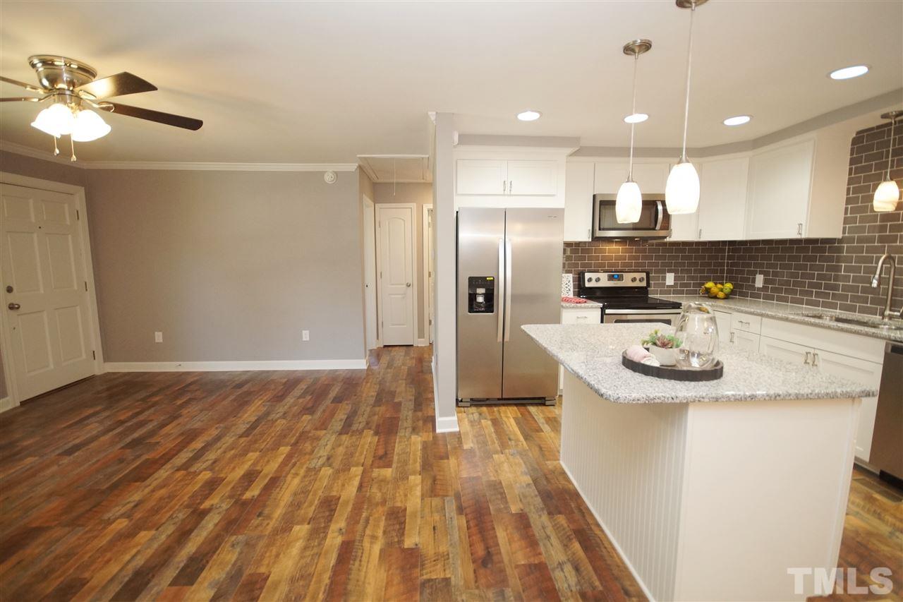2717 Knowles Street Raleigh, NC 27603 - Photo 11 of 26 a kitchen with kitchen island a sink appliances and cabinets