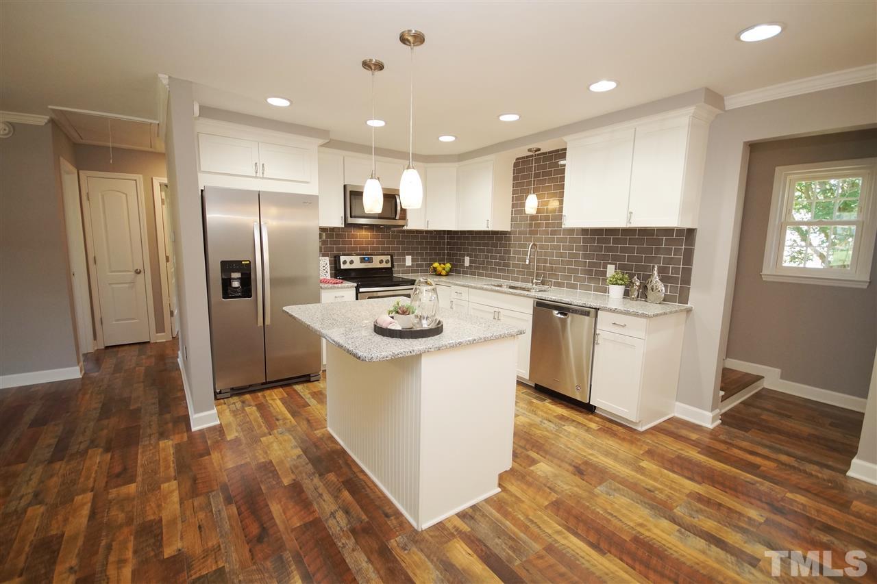 2717 Knowles Street Raleigh, NC 27603 - Photo 12 of 26 a kitchen with a sink a refrigerator and cabinets