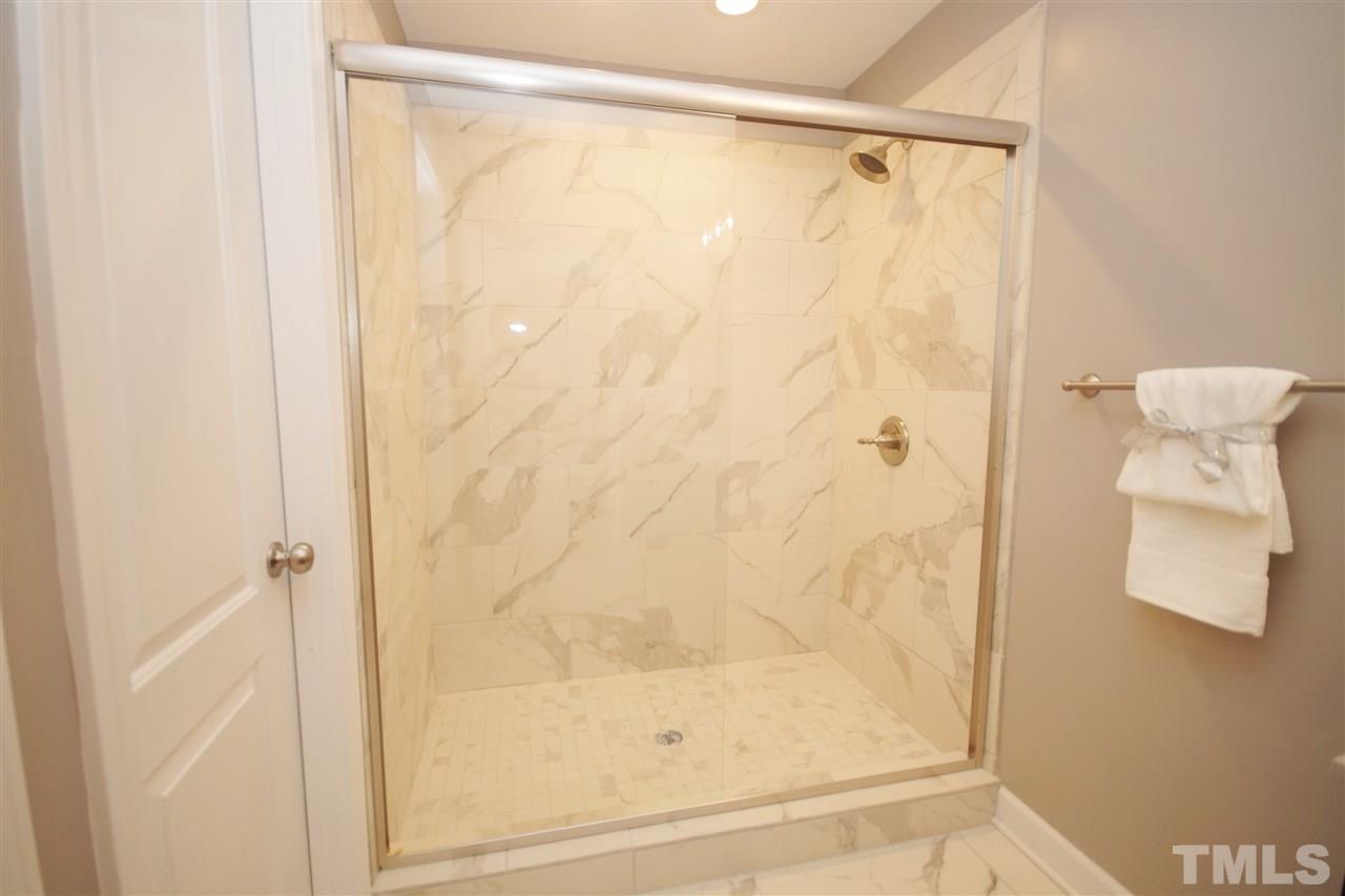 2717 Knowles Street Raleigh, NC 27603 - Photo 18 of 26 a bathroom with a glass shower door