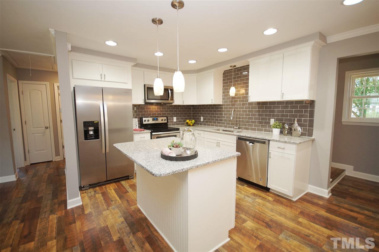 2717 Knowles Street Raleigh, NC 27603 - Photo 7 of 26 a kitchen with stainless steel appliances granite countertop a sink stove and refrigerator