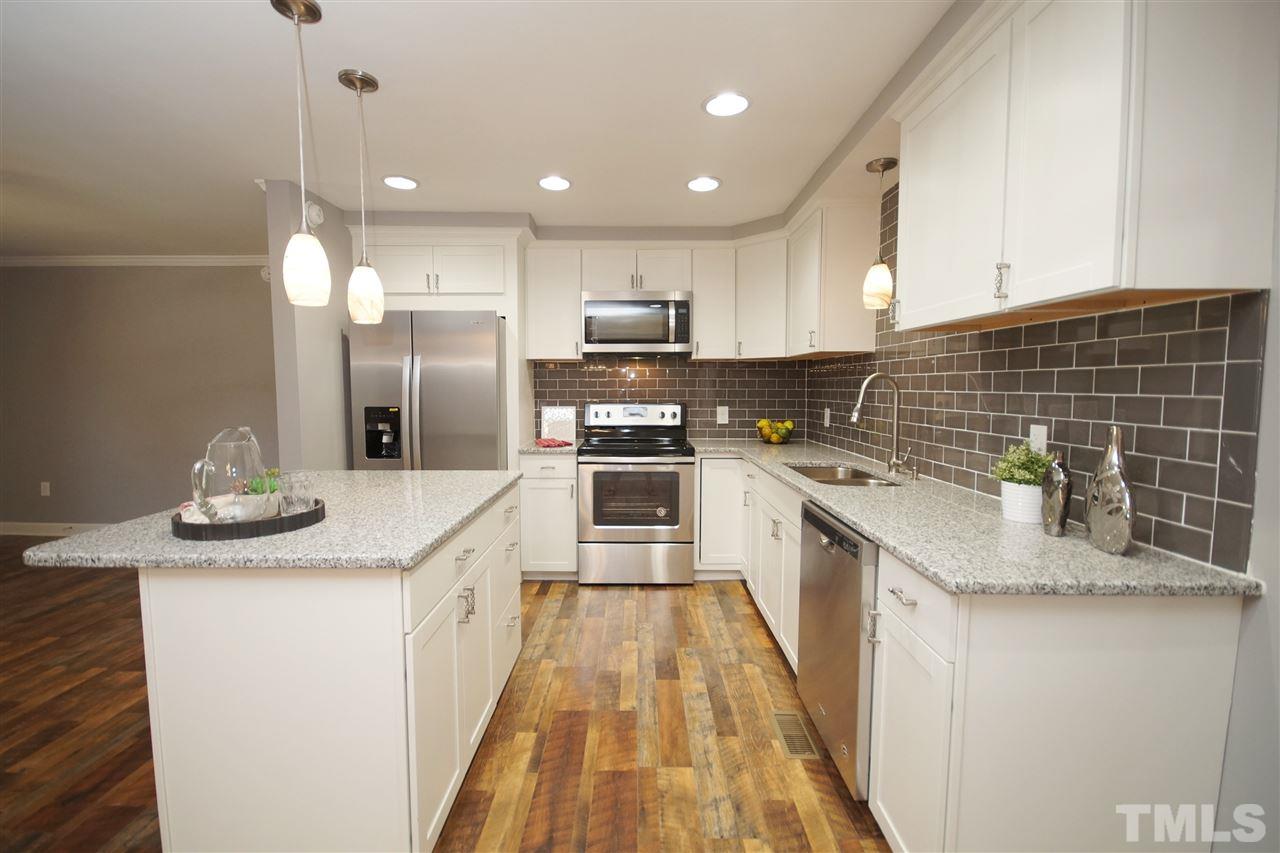 2717 Knowles Street Raleigh, NC 27603 - Photo 9 of 26 a kitchen with stainless steel appliances kitchen island granite countertop a sink and cabinets