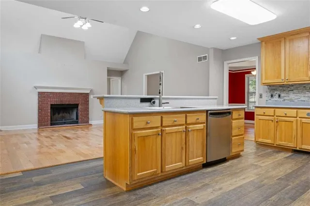 a kitchen with granite countertop wood cabinets stainless steel appliances and sink