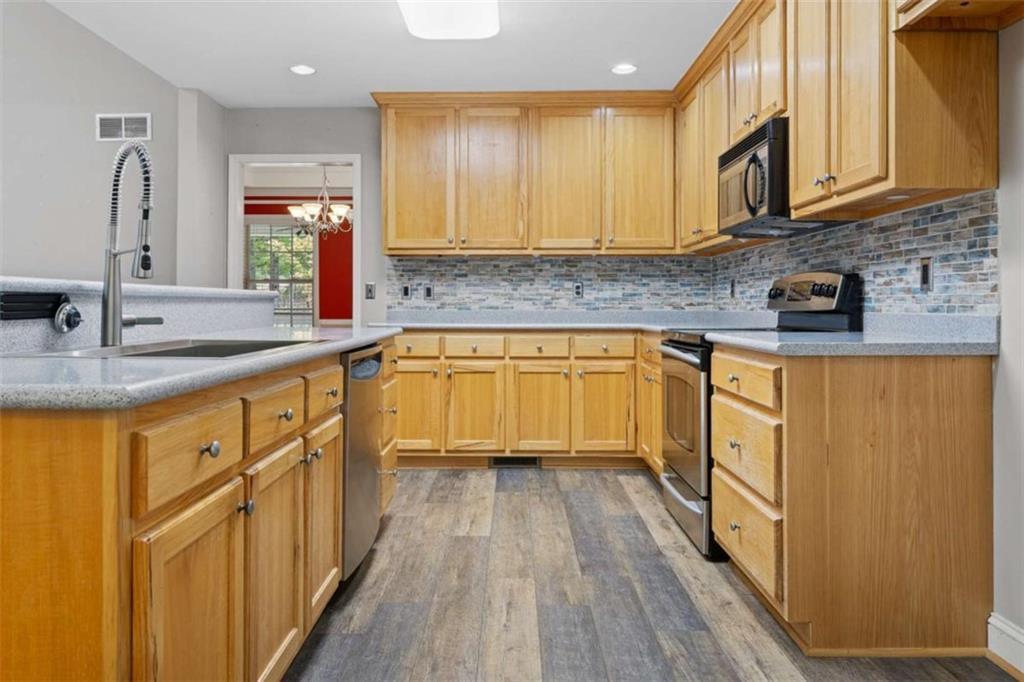 9375 Brian Boulevard Winston, GA 30187 - Photo 17 of 70 a kitchen with stainless steel appliances granite countertop wooden cabinets a sink and dishwasher a stove with wooden floor