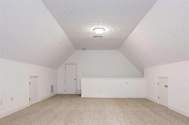 a house that is sitting in the grass with large trees