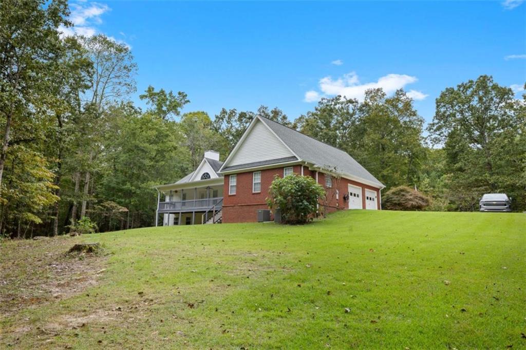 9375 Brian Boulevard Winston, GA 30187 - Photo 63 of 70 a house that is sitting in the grass with large trees