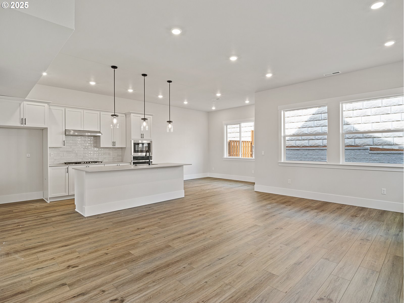 18045 Southwest Monashee Lane Beaverton, OR 97007 - Photo 7 of 45 a large kitchen with stainless steel appliances a large counter top a sink and a wooden floors